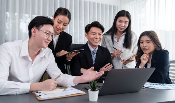 Harmony in office concept as business people analyzing dashboard paper together in workplace. Young colleagues give ideas at manager desk for discussion or strategy planning about project.
