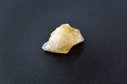 Natural stone of untreated citrine crystal, yellow quartz. Selective focus, black background