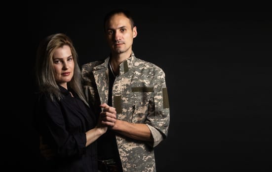 Happy woman hugging his husband came back from army. Smiling cheerful caucasian girlfriend embracing a soldier