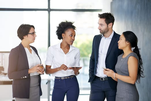 Communication is the key to success. a group of businesspeople talking in the office