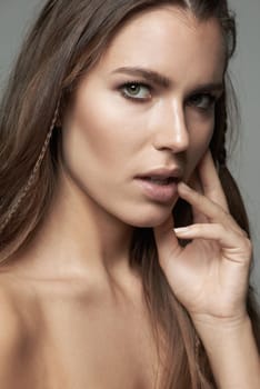 Beauty in simplicity. a beautiful young woman against a gray background