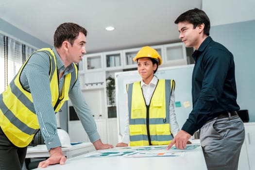 A group of competent engineers and employer discuss plans in the office. Architectural investor, businessman, and engineer discussing blueprints.