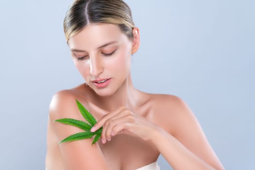 Alluring beautiful woman model portrait holding green leaf as concept for cannabis skincare cosmetic product for skin freshness treatment in isolated background.