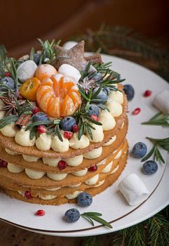 Homemade Christmas cake on rustic wooden stand and holiday decoration