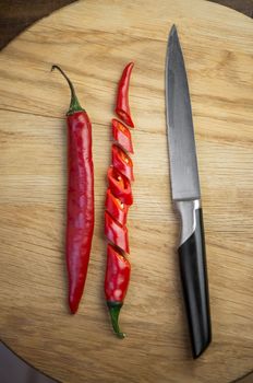Red chili pepper cut into pieces on a wooden background. Hot spice, red chili