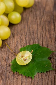 Juicy green grapes - macro shot of whole and cut berries on wooden