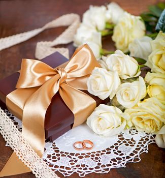 bouquet of white rose with green leaves on a wooden