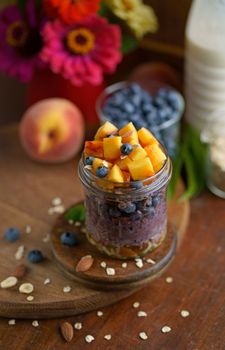 Breakfast yogurt granola parfait with peach and blueberry in a jar, healthy food
