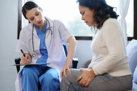 Portrait of a female doctor talking to a patient with knee pain