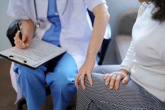 Portrait of a female doctor talking to a patient with knee pain