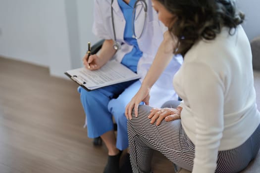 Portrait of a female doctor talking to a patient with knee pain