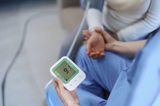 Portrait of female doctor measuring patient's blood pressure before treatment