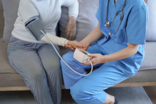 Portrait of female doctor measuring patient's blood pressure before treatment