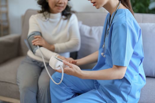 Portrait of female doctor measuring patient's blood pressure before treatment