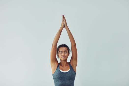 Yoga is the journey and the destination. Studio shot of an attractive young woman practicing yoga against a grey background