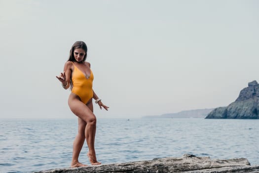 Woman meditating in yoga pose silhouette at the ocean, beach and rock mountains. Motivation and inspirational fit and exercising. Healthy lifestyle outdoors in nature, fitness concept.