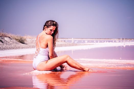 Salt mining. Salty pink lake with crystals of salt. Extremely salty pink lake, colored by microalgae with crystalline salt depositions