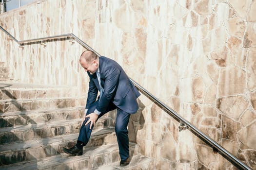 Portrait of a senior professional man in a suit with various problems. A middle-aged businessman with a briefcase descends the stairs.