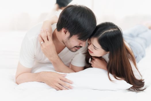 Beautiful asian couple in love and smiling sitting on bed. Romantic moment, relationships, family concept