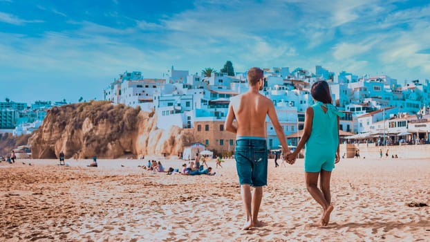 happy Young couple walking at the beach of Albufeira Algarve Portugal Algarve during summer