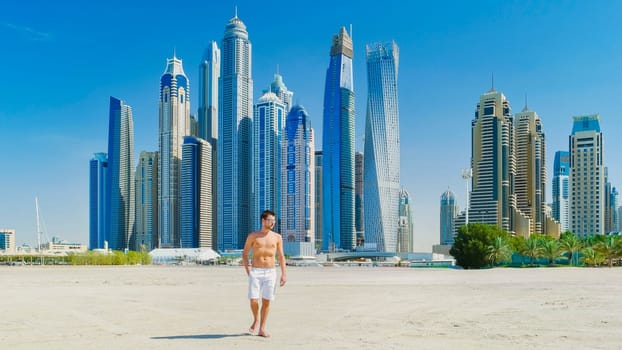 Young man in a swim short on the beach in Dubai, Jumeirah beach Dubai United Arab Emirates on a sunny day.