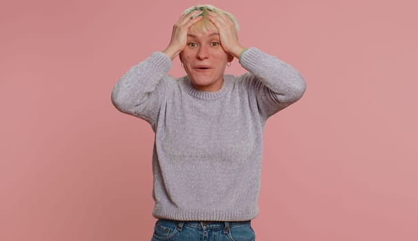 Happy joyful woman with short hair shouting raising hands in gesture I did it, celebrating success, winning, birthday, lottery jackpot goal achievemen. Girl on pink background. Lgbt gay lesbian people