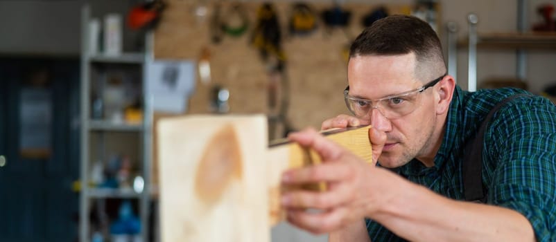 Carpenter measures wooden planks in the workshop