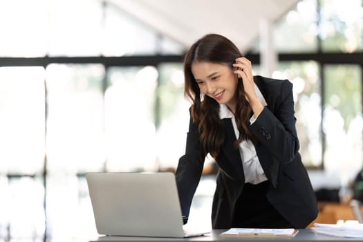 Young successful woman entrepreneur or an office worker work with desk in a modern office,have happy to work.