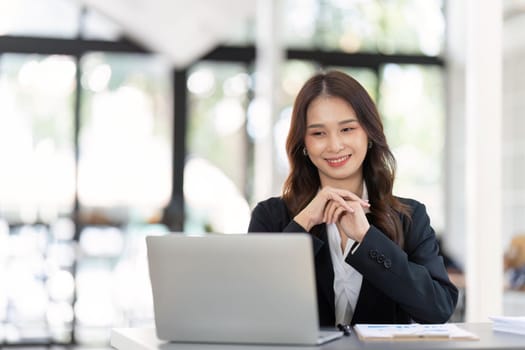 Young successful woman entrepreneur or an office worker work with desk in a modern office,have happy to work.
