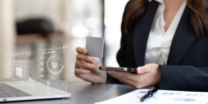 Woman using credit card to make purchases on mobile phone, online shopping concept.