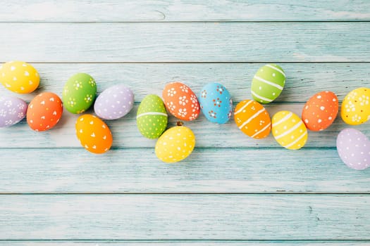 Easter Day Concept. Top view holiday banner background web design white colorful easter eggs painted on blue wood background with empty copy space, celebration greeting card, overhead, template