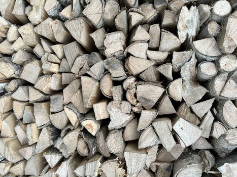 Natural wooden background - closeup of chopped firewood. Firewood stacked and prepared for winter. Wooden natural sawn logs as background