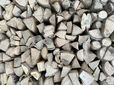 Natural wooden background - closeup of chopped firewood. Firewood stacked and prepared for winter. Wooden natural sawn logs as background