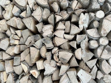 Natural wooden background - closeup of chopped firewood. Firewood stacked and prepared for winter. Wooden natural sawn logs as background