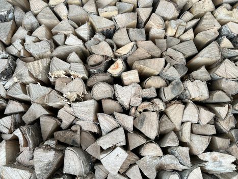 Natural wooden background - closeup of chopped firewood. Firewood stacked and prepared for winter. Wooden natural sawn logs as background