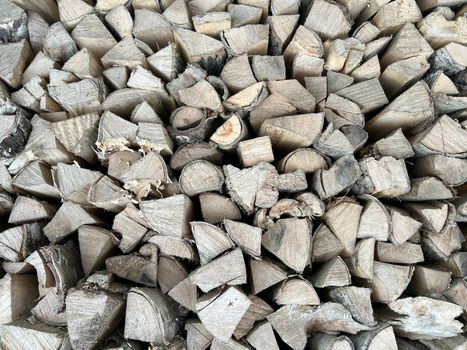 Natural wooden background - closeup of chopped firewood. Firewood stacked and prepared for winter. Wooden natural sawn logs as background