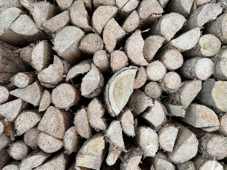 Natural wooden background - closeup of chopped firewood. Firewood stacked and prepared for winter. Wooden natural sawn logs as background
