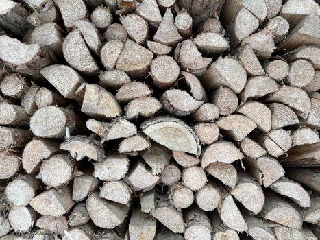 Natural wooden background - closeup of chopped firewood. Firewood stacked and prepared for winter. Wooden natural sawn logs as background