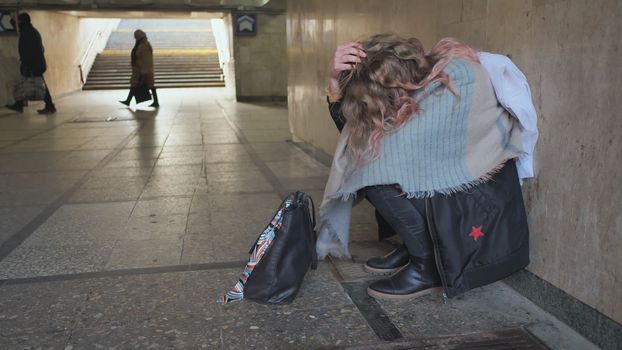 A lonely, sad girl sitting in an underpass