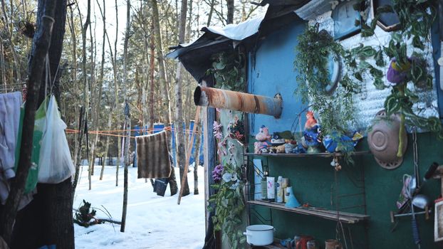 The homeless come out of their hut in the winter in the woods