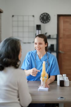 Portrait of a female doctor talking to an elderly patient about osteoarthritis