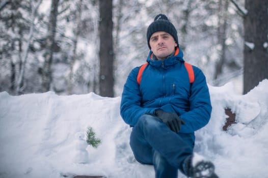 Man in winter jacket walking in snowy winter forest, snowy winter day