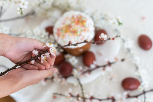 hands holding painted eggs. Easter cake.