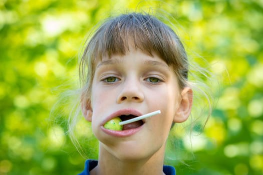 The girl has a big round lollipop in her mouth, close up portrait