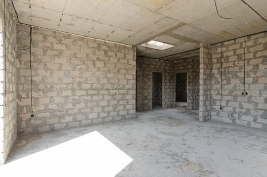 Construction of an individual residential building, a large spacious room with a concrete floor and reinforced concrete ceilings a