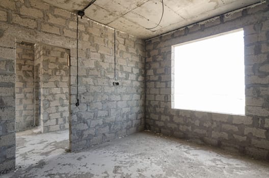 Construction of an individual residential building, view of two walls, interior with a doorway and exterior with a window opening a