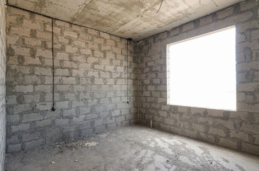 Construction of an individual residential building, view of two walls, blind interior and exterior with a window opening a