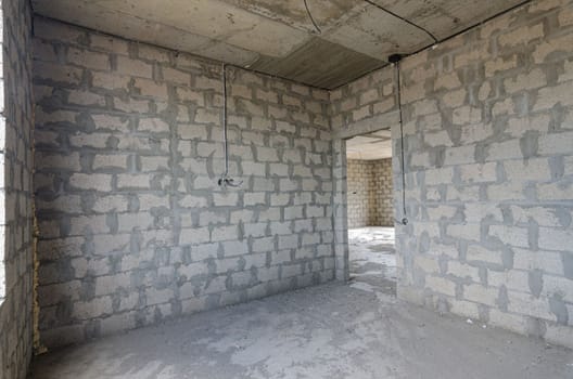 Construction of an individual residential building, view of the corner of the room, one of the walls with a doorway a