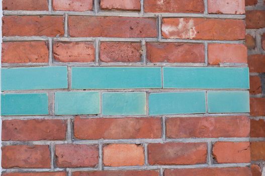 natural red brick background, masonry texture, house stone wall with blue color ceramic tiles insert. High quality photo