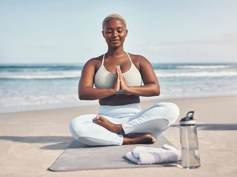 Yoga has gifted me with the potential toward inner awakening. a woman meditating during her yoga routine on the beach